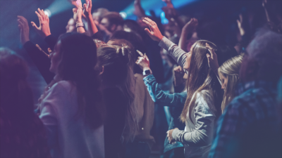how to track church attendance to gauge church growth blog header - group of people worshipping with arms raised