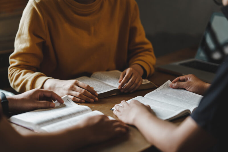 Christian couple or group reading study the bible together and pray at a home or Sunday school at church. concept studying the word of god.